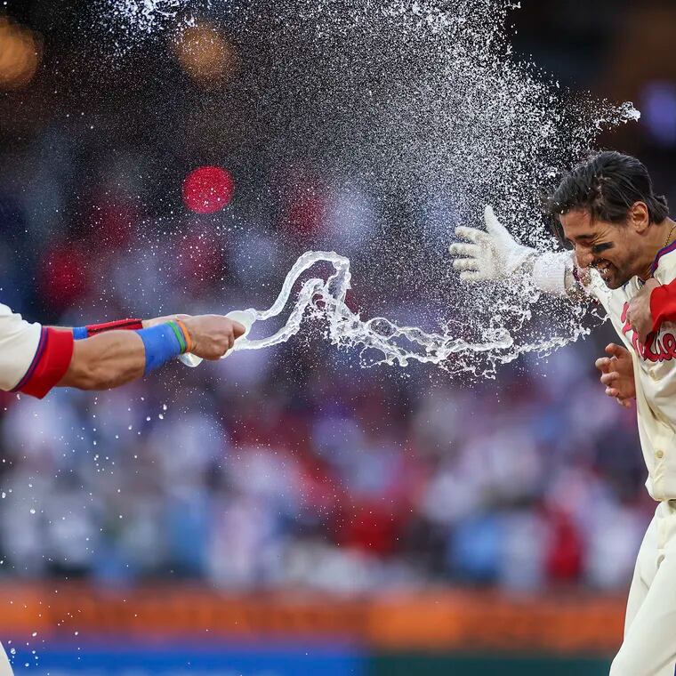 Philadelphia Phillies outfielder Nick Castellanos is doused in water by Philadelphia Phillies designated hitter Kyle Schwarber after his walk-off single to win it for the Phillies in the ninth inning.