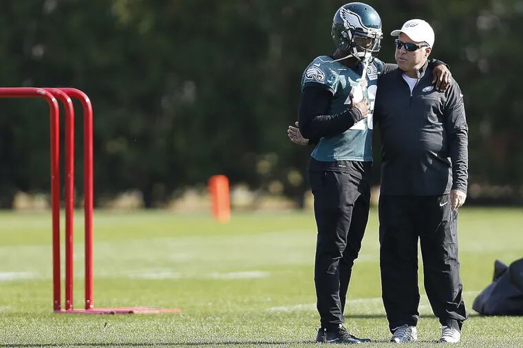 Eagles owner Jeff Lurie puts arm around receiver Josh Huff at  practice on Wednesday.