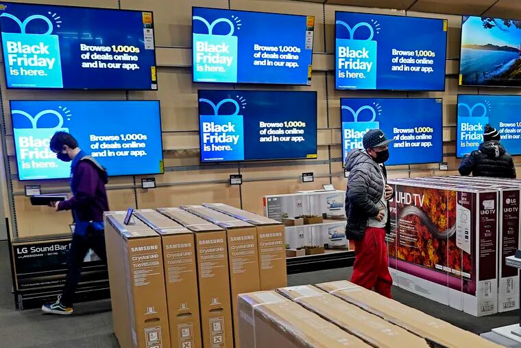 People look at televisions during a Black Friday sale at a Best Buy store Friday, Nov. 26, 2021, in Overland Park, Kan. Prices are higher everywhere, even online, as companies adopt more personalized strategies based on a shopper's buying history. (AP Photo/Charlie Riedel)