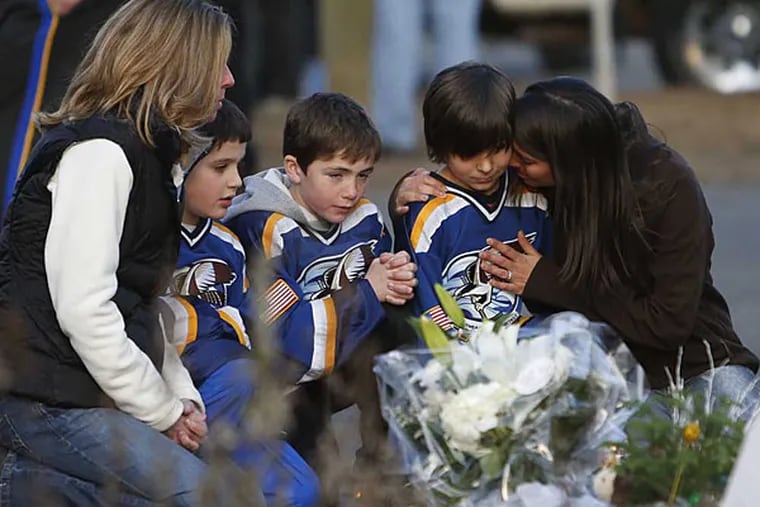 From left, Jean Bradley, Steven Turchetta, 9, Jean's son Matthew Bradley, 9, Ashton Baltes, 10, and his mother Elonda Baltes pay their respects at a memorial for shooting victims near Sandy Hook Elementary School,