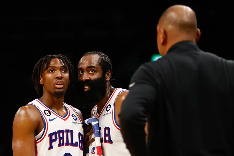 Sixers guard James Harden talks to teammate guard Tyrese Maxey as former head coach Doc Rivers looks on.