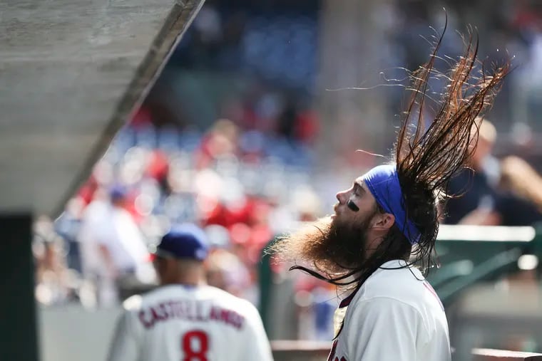 Phillies outfielder Brandon Marsh wets his hair in the dugout before a game in May.