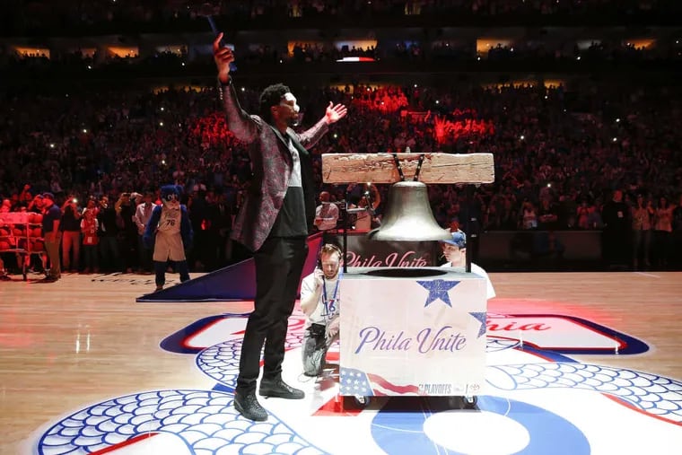 Sixers center Joel Embiid raises his arms while riding the ceremonial Liberty Bell before the Sixers played the Miami Heat in game one of the Eastern Conference quarterfinals on Saturday, April 14, 2018 in Philadelphia.