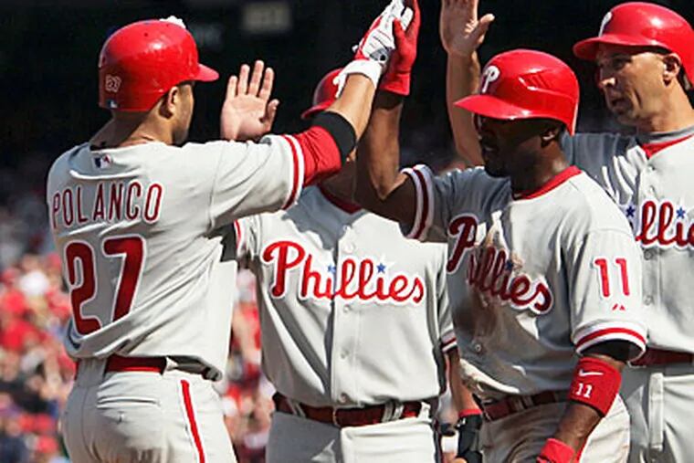 Placido Polanco celebrates his seventh inning grand slam with teammates Carlos Ruiz, Jimmy Rollins and Raul Ibanez. (Yong Kim / Staff Photographer)