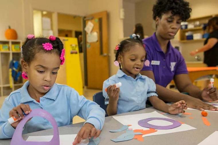 Four-year-olds Lyriq Brooks (left) and Ceyanee Brown work with pre-K teacher Shannon Hurley at the Columbia North YMCA.