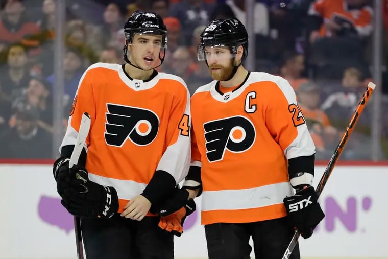 Morgan Frost (left) talking to linemate Claude Giroux in a game earlier in the year.