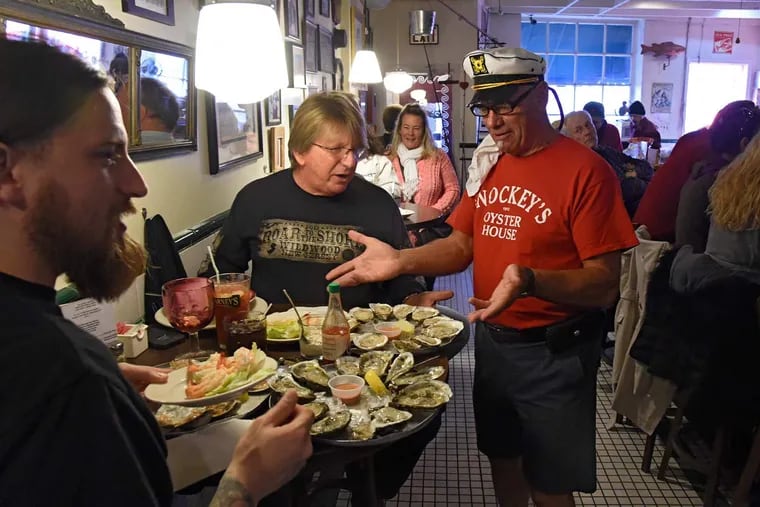 Ken Snock — wearing his skipper’s cap — said bon voyage to Snockey’s, while longtime customer Salvatore Belluso (center) returned with his son Shawn for one last plate of oysters.