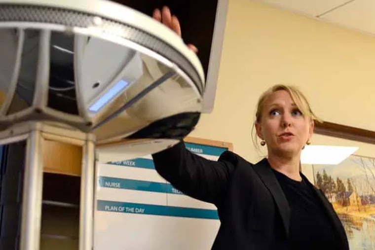 Rachel Sparks (cq) Xenex technical director out of San Antonio, sets up demonsration of the company's pulse UV disinfection system at Doylestown Hospital March 19, 2013. ( TOM GRALISH / Staff Photographer )