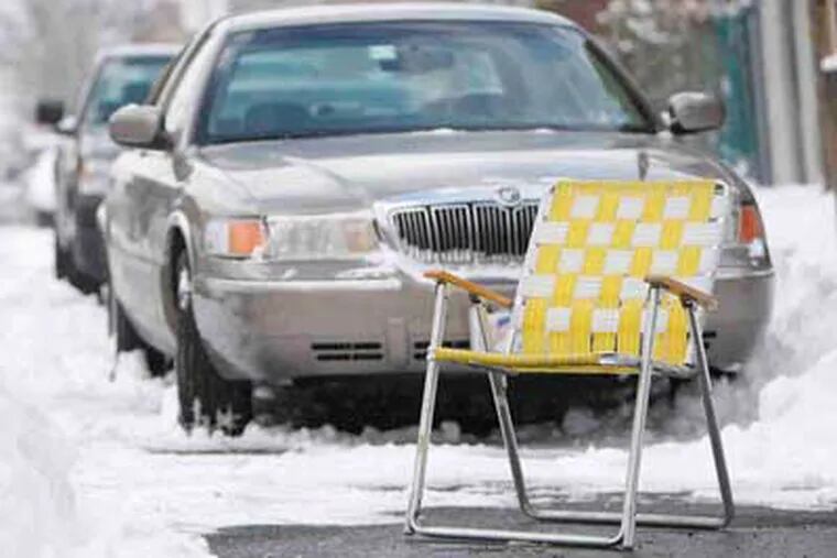 A driver saves a parking spot with a lawn chair yesterday on Shunk Street in South Philly.  (David Maialetti / Staff photographer)