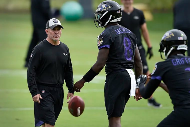 James Urban, left, working with Robert Griffin III, right, and Lamar Jackson at the team's training facility last June.