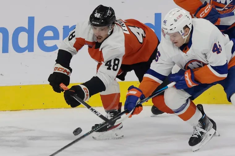 Morgan Frost and the Islanders' Karson Kuhlman battle for the puck in a preseason game.
