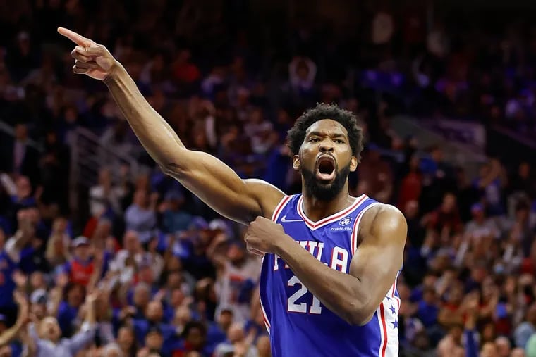 Sixers center Joel Embiid points after making a basket against the Toronto Raptors in Game 1.