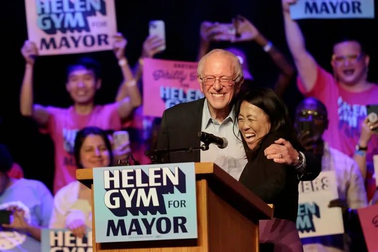 Philadelphia mayoral candidate Helen Gym (right) welcomes U.S. Sen. Bernie Sanders to the stage during a rally at Franklin Music Hall in Philadelphia Sunday on the last weekend before Tuesday's primary election.