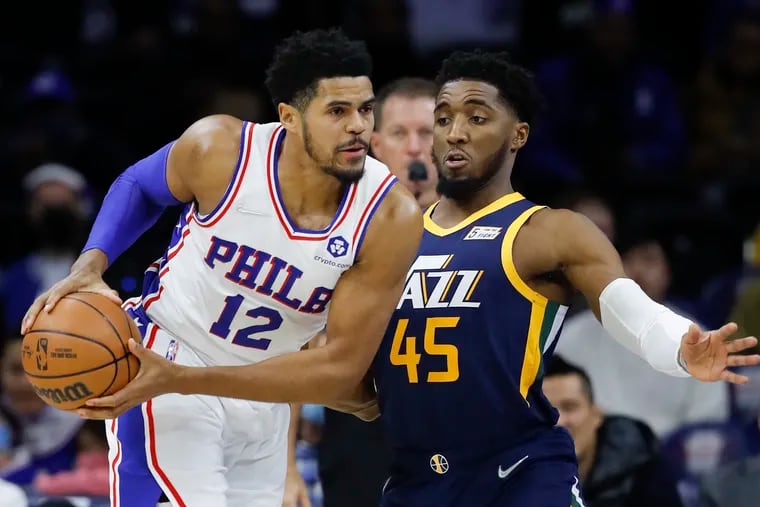 Sixers forward Tobias Harris holds the basketball as Utah Jazz guard Donovan Mitchell defends.