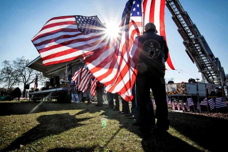 Members of the Warrior Lodge Riders of New Jersey hold American flags during the Camden County Freeholder Board's annual Veteran's Day observance on the Cooper River in Pennsauken Sunday, November 11, 2018. A plaque listing the names of Camden County residents killed in World War I was unveiled at the event.