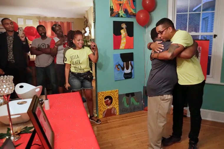 Fifth District Community Relations Officer Maurice Scott (right) and co-worker Officer Robert Long hug during a surprise party for Scott, thrown by his fellow officers on October 2.