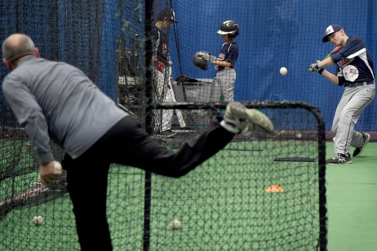 Assistant coach Alan Tauber pitches batting practice to Jack Donahue, 14, during training in Bala Cynwyd.