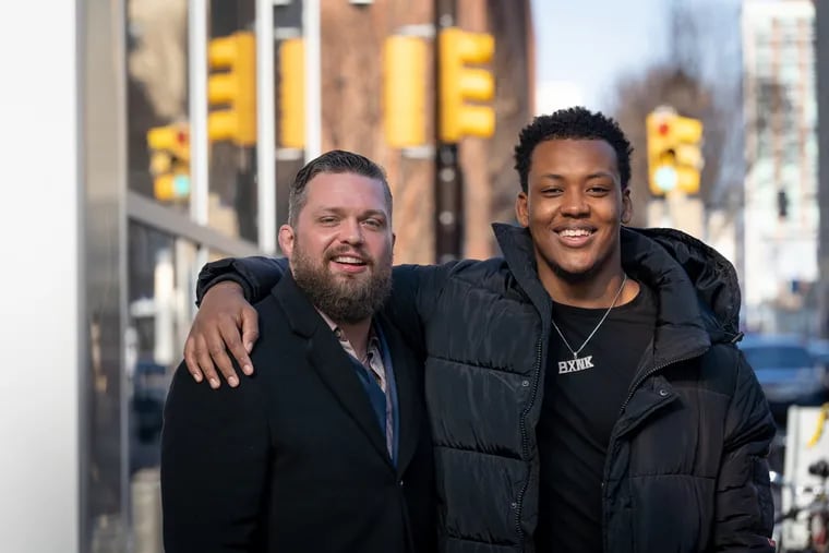 Foster father Jackson Duncan, left, founder of Focused Athletics, a non-profit that helps Philadelphia inner-city high school athletes, and College freshman Zymir Cobbs shown here outside family court, after Cobbs is officially adopted by Duncan, in Philadelphia, January 15, 2020.