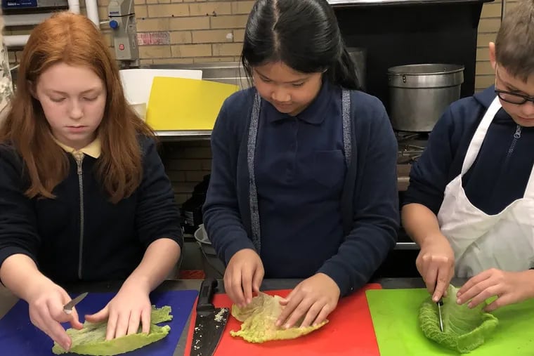 Ava Stuchko, Stella Chau and Travis Chopyak get the cabbage leaves ready for turkey Golapkis during week 3 of the Fall 2018 My Daughter's Kitchen cooking program at Comly.