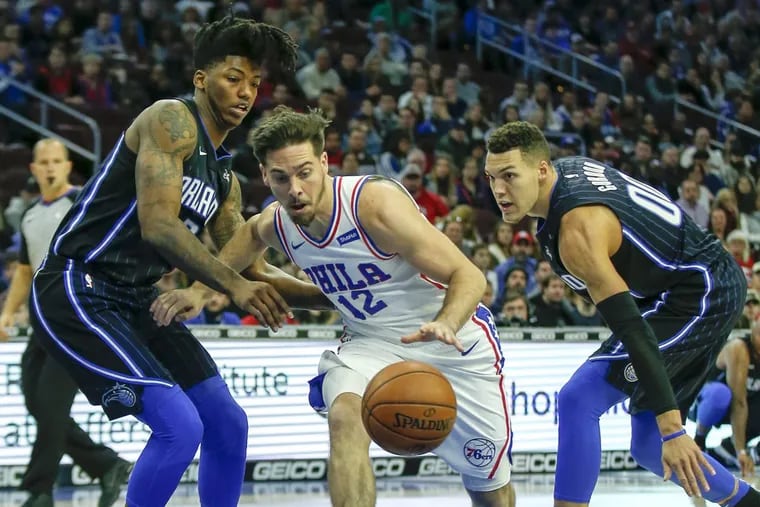 Sixers guard T.J. McConnell dribbles between Orlando guard Elfrid Payton (left) and forward Aaron Gordon on Saturday, Nov. 25, 2017.