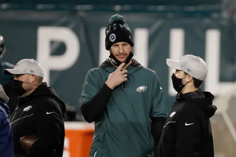 Eagles quarterback Carson Wentz lowers his face mask before the team's game Sunday night against the Washington Football Team.