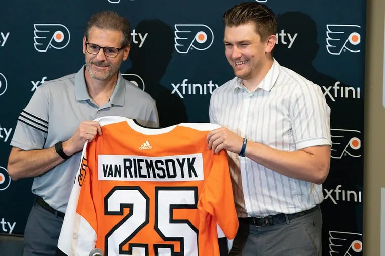 Ron Hextall, left, and left winger James van Riemsdyk are shown during a news conference after he signed with the team this summer. Van Riemsdyk's injury has left a major void in the team's identity.