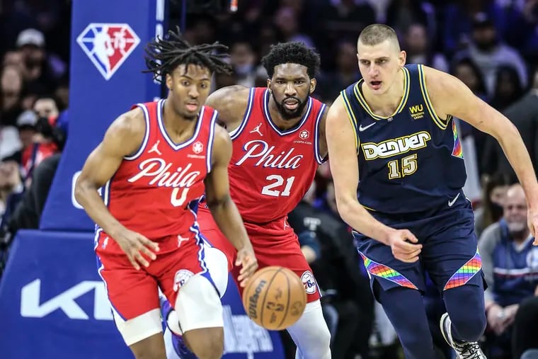 Sixers Tyrese Maxey, Joel Embiid watch the loose ball with  Nuggets Nikola Jokic during the 1st quarter at the Wells Fargo Center in Philadelphia, Monday,  March 14, 2022.