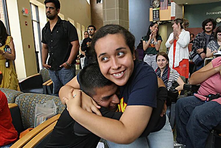 Maria Ibarra,19, originally from Durango, Mexico, and Candido Renteria, 24, of Monterrey Nuevo Leon, hug with joy in Edinburg, Texas, after President Obama announced he would ease enforcement of immigration laws on Friday. Many students gathered at the student union at the UTPA Campus in Edinburg to watch the announcement. DELCIA LOPEZ / The Monitor