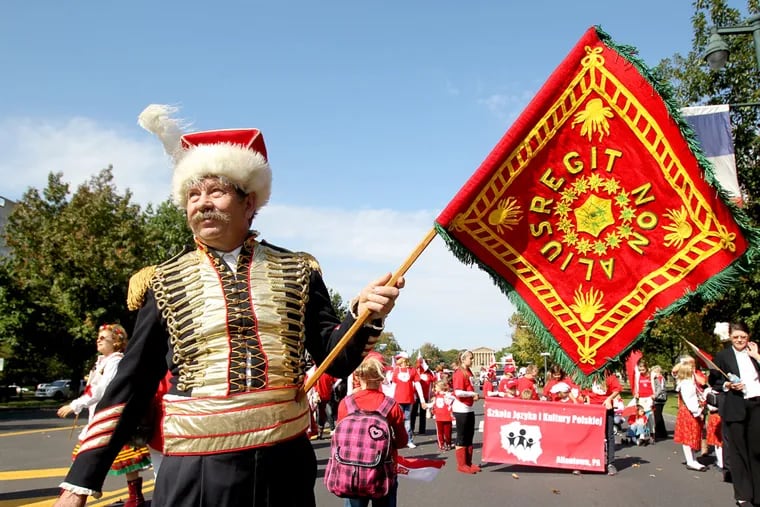 Joseph Janik of the Polish National Alliance Council 171 of the Lehigh Valley stands with a replica of the banner carried by Gen. Casimir Pulaski during the Revolutionary War. Janik was marching in the 2012 Pulaski Day Parade.  ( Charles Fox / Staff Photographer )
