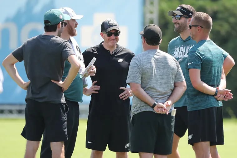 Eagles GM Howie Roseman (center) talks with team personnel after practice at the NovaCare facility in Philadelphia, Pa. on Sunday, Aug. 20, 2023.