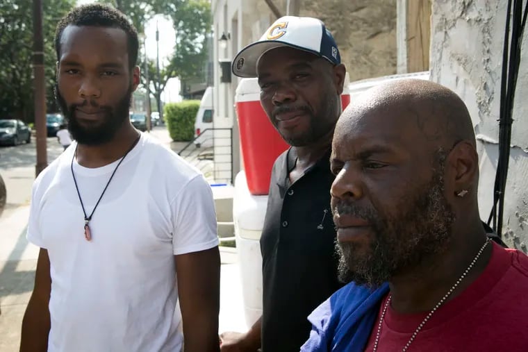 The family of Norman Smith Sr., whose body was found wrapped in plastic in July, mourns their relative death at their family home on Tuesday, August 7, 2018. From left, Norman's son, Norman Smith Jr., with Norman's brothers, Ernie and Walter Smith.