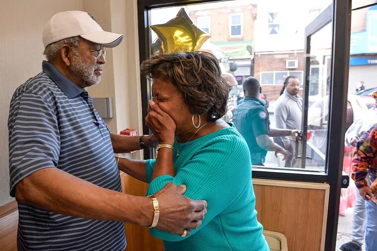 Denise Gause is overwhelmed with emotion and receives a hug from husband Rudy as Cakes by Denise re-opens after being closed for a year after being destroyed by a fire.