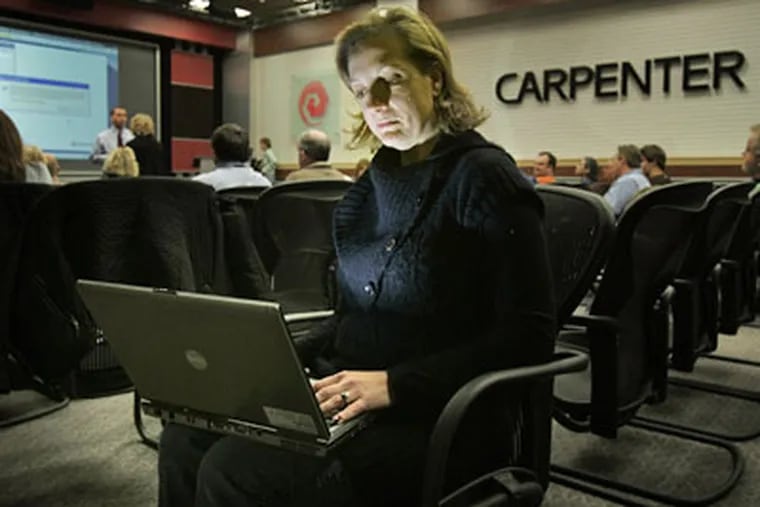 Kristen Haas of Carpenter Technology Corp. in Reading looks into a laptop computer during an online meeting with out-of-town employees rather than spending the money to travel. (Laurence Kesterson / Staff Photographer)
