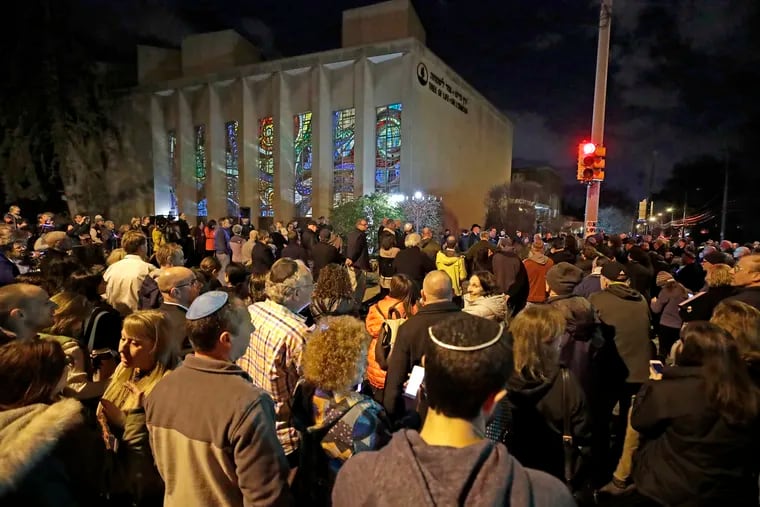 Rabbi Jeffrey Myers leads a gathering in Hanukkah songs after lighting a menorah outside the Tree of Life Synagogue on the first night of Hanukkah, Sunday, Dec. 2, 2018 in the Squirrel Hill neighborhood of Pittsburgh. A gunman shot and killed 11 people while they worshipped Saturday, Oct. 27, 2018 at the temple. (AP Photo/Gene J. Puskar)
