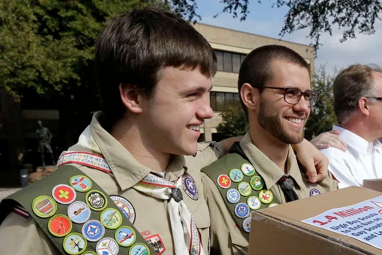 James Oliver (left) hugs his brother and fellow Eagle Scout, Will Oliver, who is gay. They presented petitions to Boy Scouts headquarters in Dallas in February.