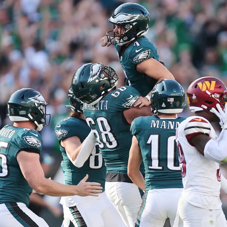 Eagles place kicker Jake Elliott celebrates with his teammates after kicking the game winning 54-yard overtime field goal to beat the Washington Commanders.