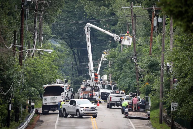 Workers repairing power lines on Palmers Mill Road near Providence Road in Media on Sunday. Storms caused tree and power line damage in area.