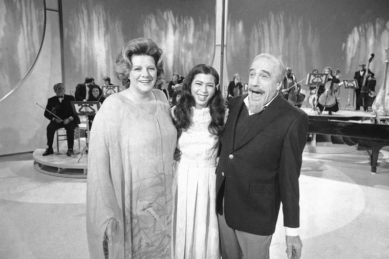 FILE - Conductor Mitch Miller performs for photographers with singers Rosemary Clooney, left, and Irene Cara, center, during a rehearsal, on Jan. 6, 1981, in New York for his NBC-TV special called "The Mitch Miller Show: A Sing Along Sampler."  Oscar, Golden Globe and two-time Grammy winning singer-actress Cara, who starred and sang the title cut from the 1980 hit movie “Fame” and then belted out the era-defining hit “Flashdance .
 What a Feeling” from 1983's “Flashdance,” has died at age 63.  Her publicist Judith A. Moose confirmed the death on Saturday, Nov. 26, 2022. (AP Photo/Richard Drew, File)