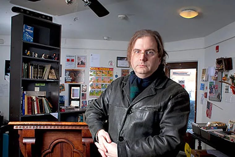 David Williams, owner of GERM - a longtime science fiction bookstore in Fishtown, stands in front of a podium that was given to him when another small bookstore went under. When asked about his store's closing, Williams shrugged and said "everybody loves a funeral." (Ed Hille / Staff Photographer)