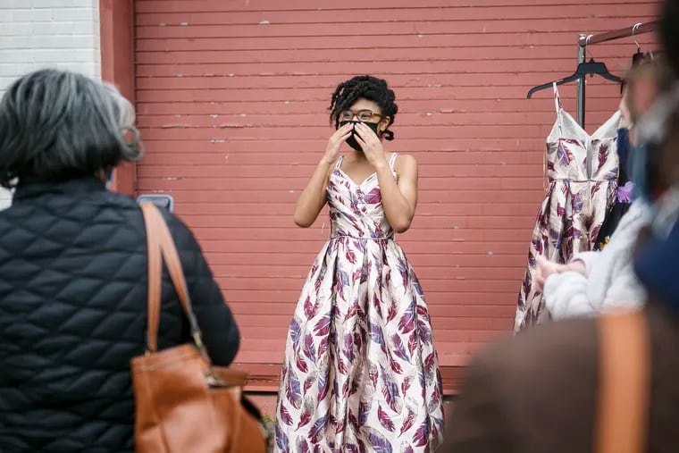 Shawn Clark, left, takes a picture of her daughter Alani Clark, 15, trying on a prom dress at Woodrow Wilson High School during a prom dress giveaway in Camden on April 17.