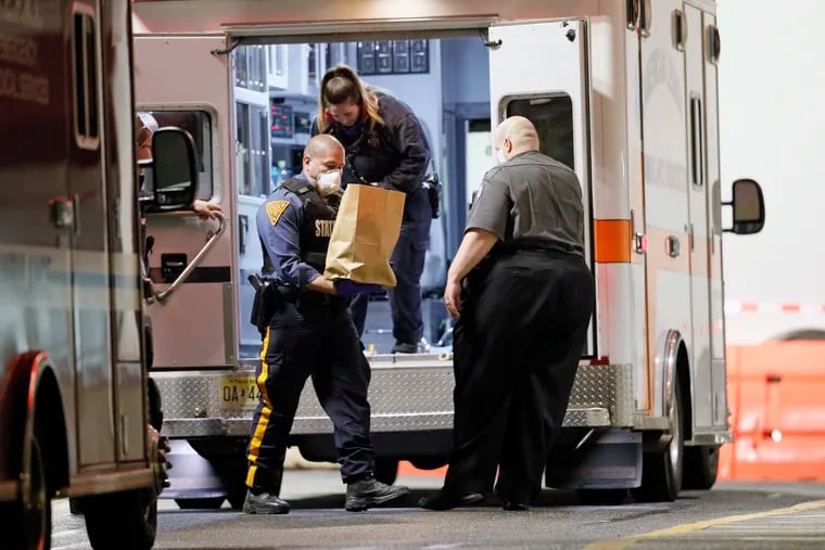 A NJ State Trooper removes items from an ambulance at Cooper Hospital just before midnight on April 25, 2020.