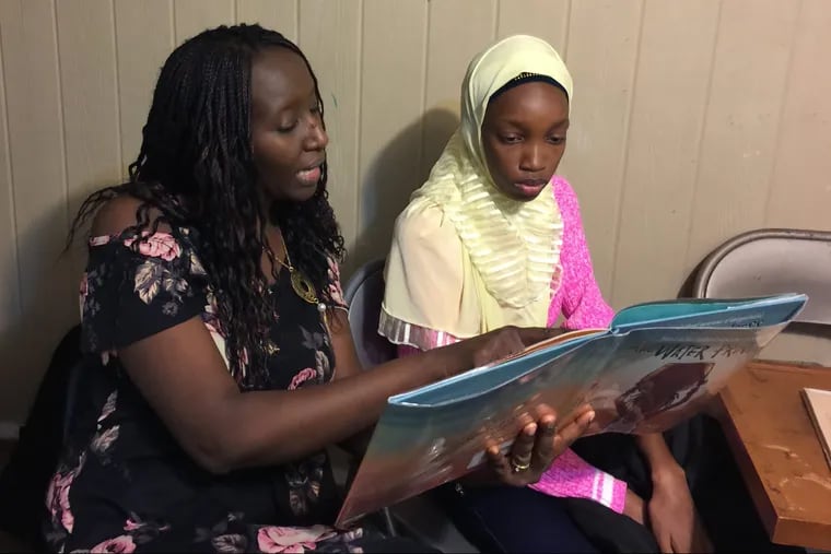 Aminata Sy reads to Dieynaba, an eighth grader from Senegal.