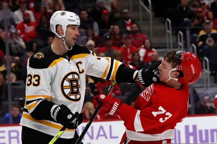 Boston Bruins defenseman Zdeno Chara (33) pushes Detroit Red Wings left wing Adam Erne (73) on Friday.