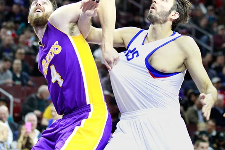 Ryan Kelly, left, of the Lakers grabs the jersey of Furkan Aldemir.  (Charles Fox/Staff Photographer)