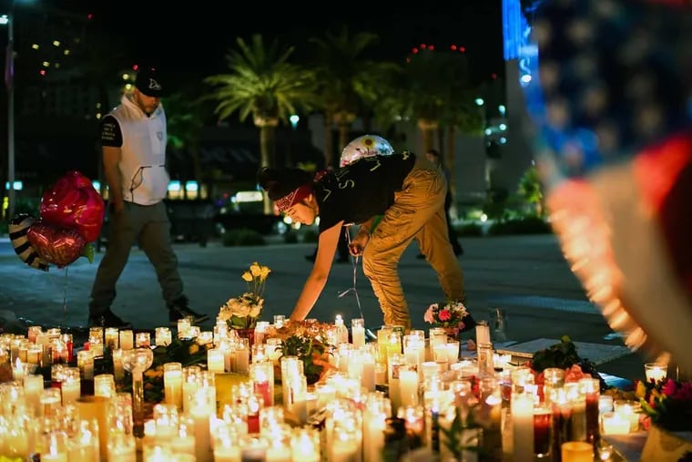 Priscilla Olivas lights a candle at a street vigil along the Las Vegas Strip on Monday.
