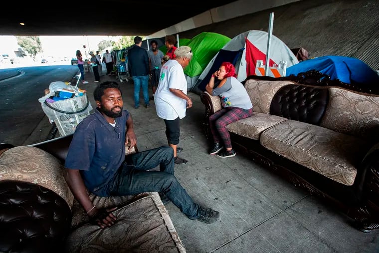 Dennis Karimi, 30, sits on a couch that also serves as his bed at a homeless encampment located under the 118 fwy in Pacoima, Calif. on July 22, 2019. Caltrans wants to oust everyone from this location, but it has been delayed due to a legal challenge.