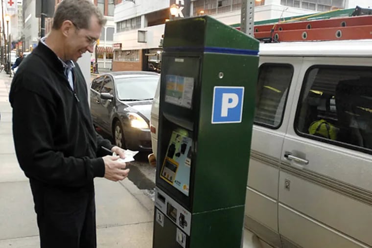 Mike McCue of Camden using a parking kiosk in 2018. Philadelphia has canceled free parking for holiday Saturdays for the first time in two decades.