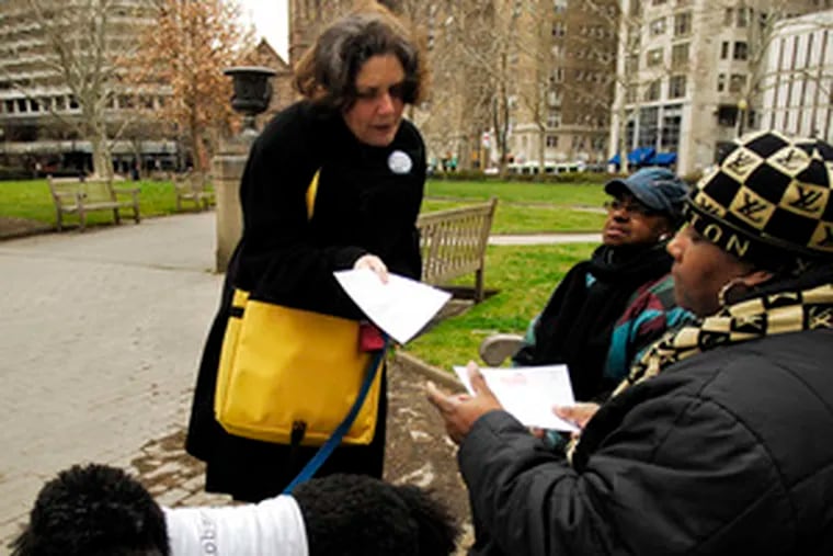 Wendy Forman, with her dog, Nelly, passing out voter registration forms to Linda Whitmore, (right) and her mother, Gloria Coleman, in Rittenhouse Square last week.
