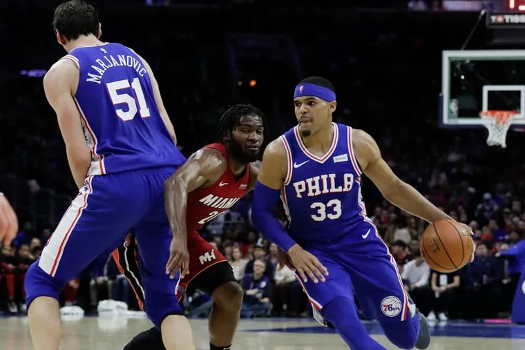 Sixers forward Tobias Harris dribbles the basketball as teammate Boban Marjanovic sets a screen on Miami Heat point guard/forward Justise Winslow.
