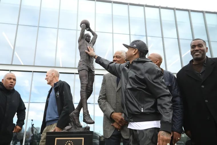 Allen Iverson lovingly touches the chest of his secret mentor, Moses Malone, as others Sixers alumni gather at the unveiling of Malone's sculpture at the Sixers' facility in Camden.